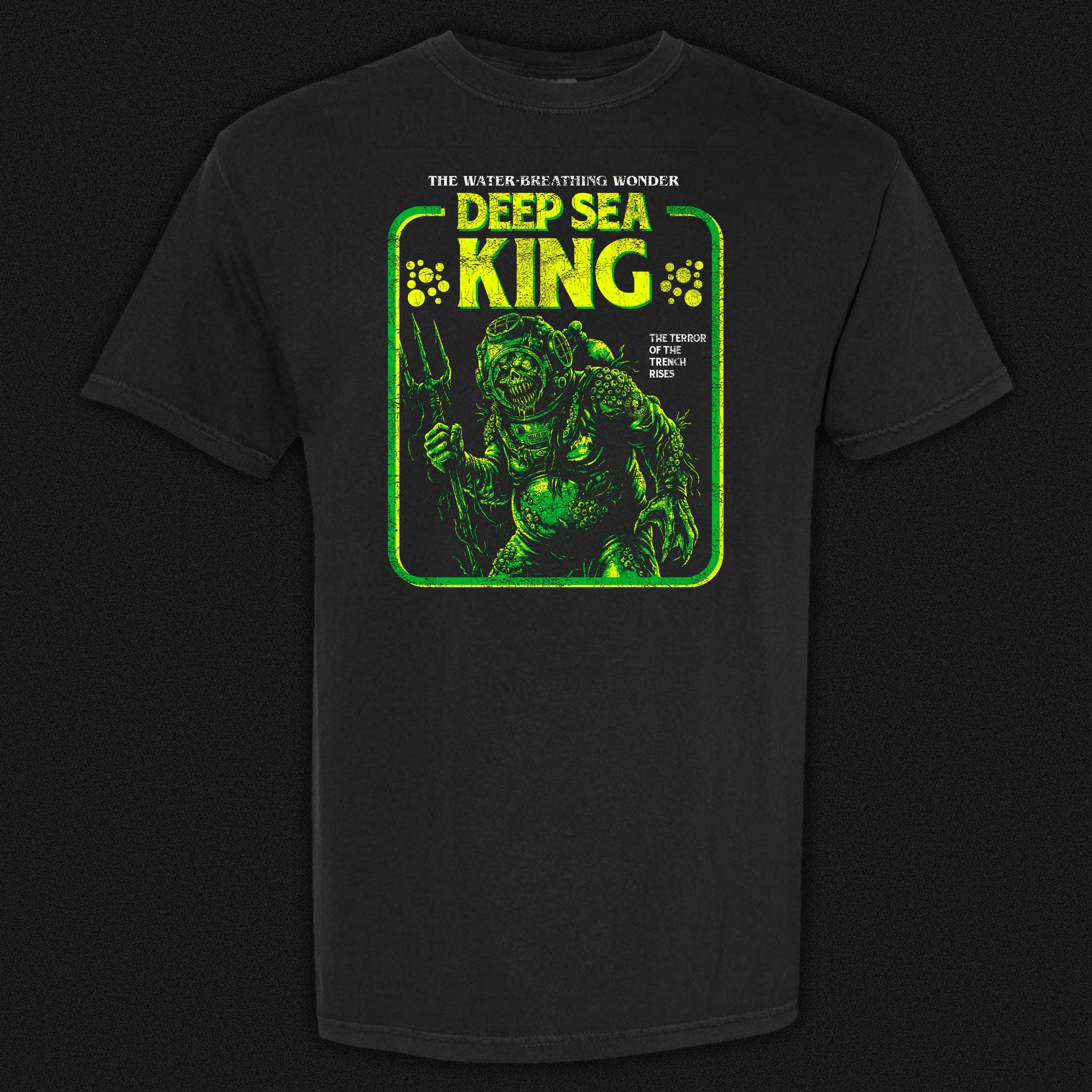 Deep Sea King vintage horror graphic tee featuring a disfigured barnacle-covered figure in an old diving suit in green and yellow on a black Comfort Colors tee.