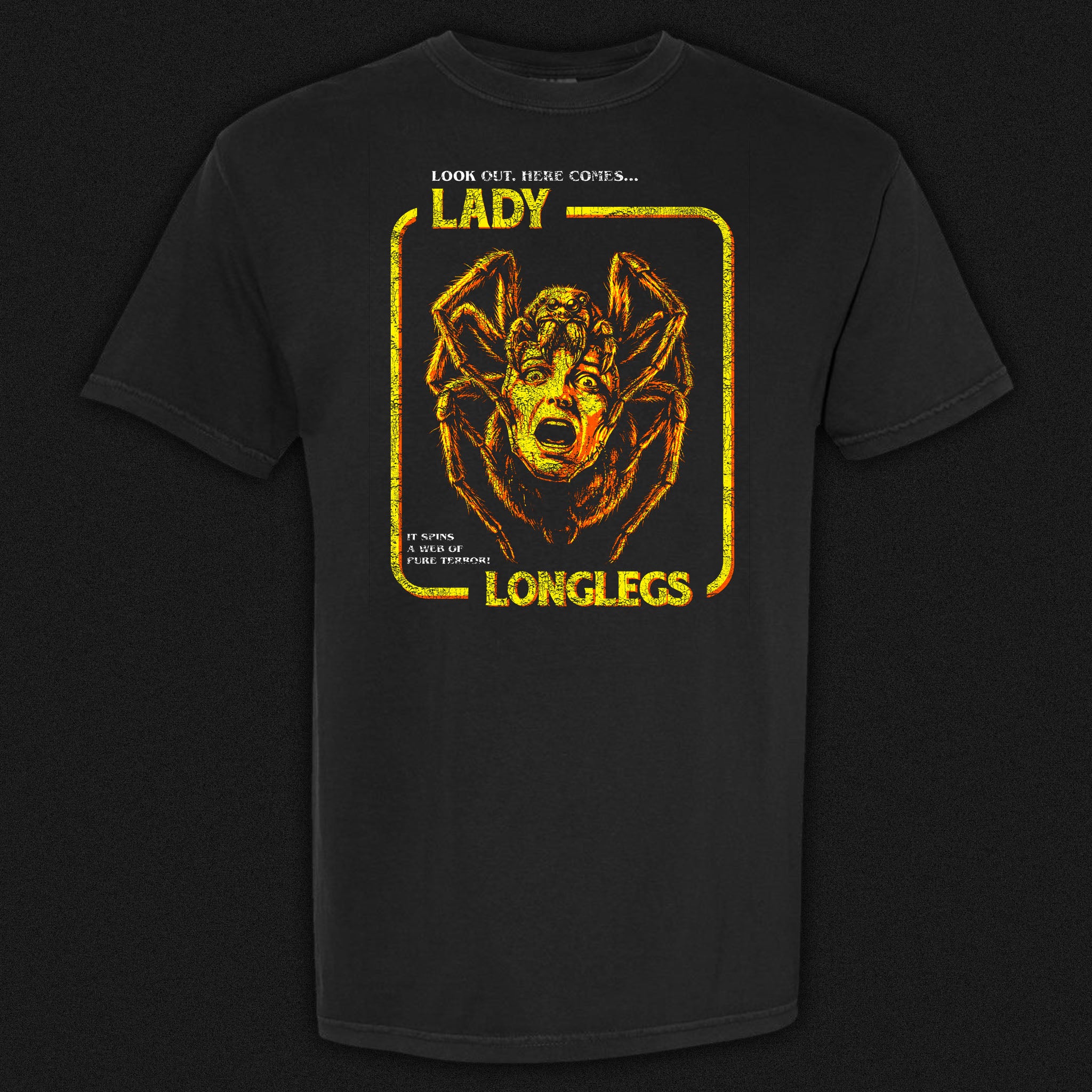 Lady Longlegs vintage horror graphic tee featuring a giant spider with a screaming woman's face in orange and yellow on a black Comfort Colors tee.